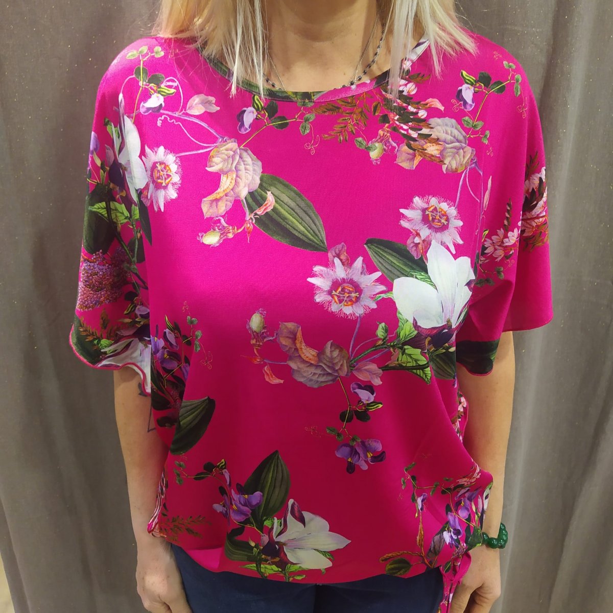 T-shirt fiori fondo fucsia in viscosa ice, manica voulant nelle taglie 48/50/52. Made in Italy