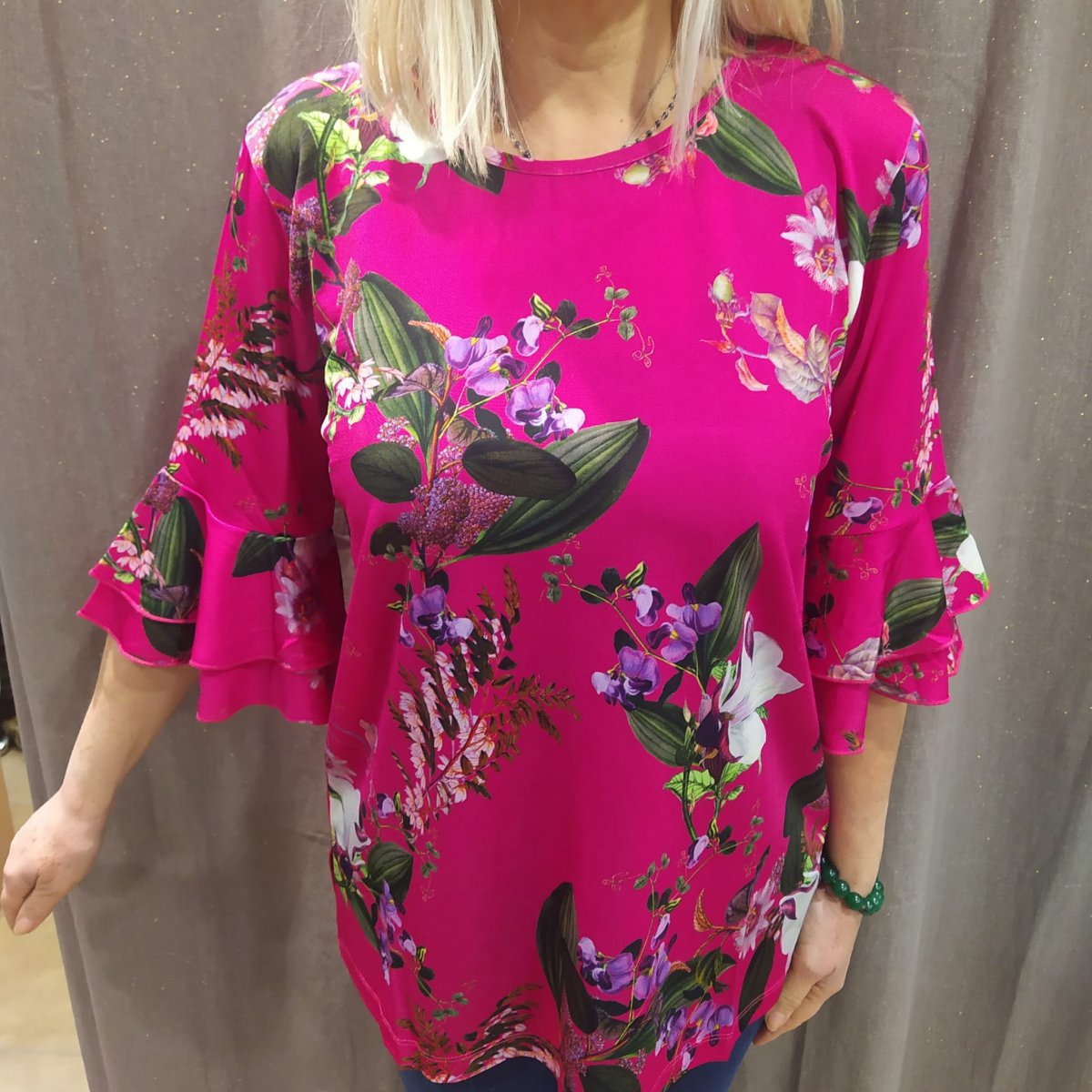 T-shirt fiori fondo fucsia in viscosa ice, manica 3/4 con voulant, disponibile solo nella taglia 46. Made in Italy.